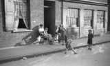 ohne Titel. (Arbeiter und spielende Jungen auf der Straße vor dem Haus, London).