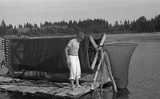 ohne Titel. (Walter Auerbach auf dem Bootssteg neben überdimensionaler Haspel mit aufgewickelter Reuse, Maine).