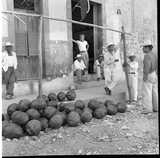 ohne Titel. (Arbeiter stehen auf der Straße, auf der Melonen liegen).